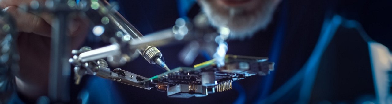 전자 유지보수 엔지니어가 마더보드 마이크로칩과 회로 기판을 납땜하는 모습