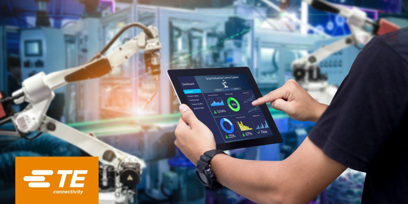 産業現場でロボットアームを操作するスマートデバイスを使用している人物の画像