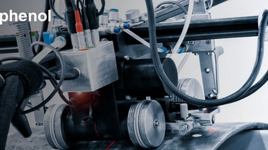 Close-up of Amphenol industrial machinery, featuring complex components, wiring, and metal parts.