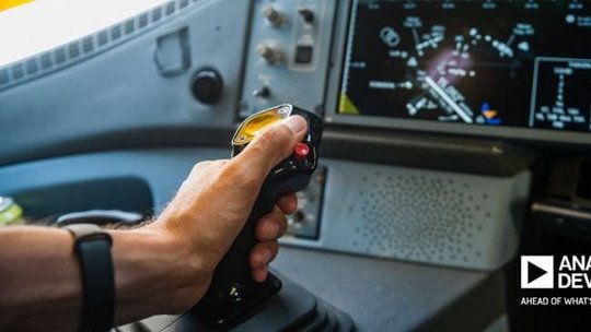 Hand operating joystick in cockpit setting