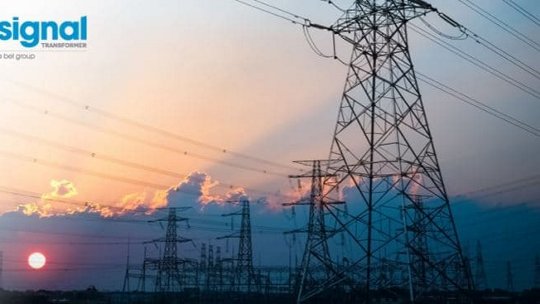 A scenic view of multiple electrical transmission towers silhouetted against a vibrant sunset sky. 