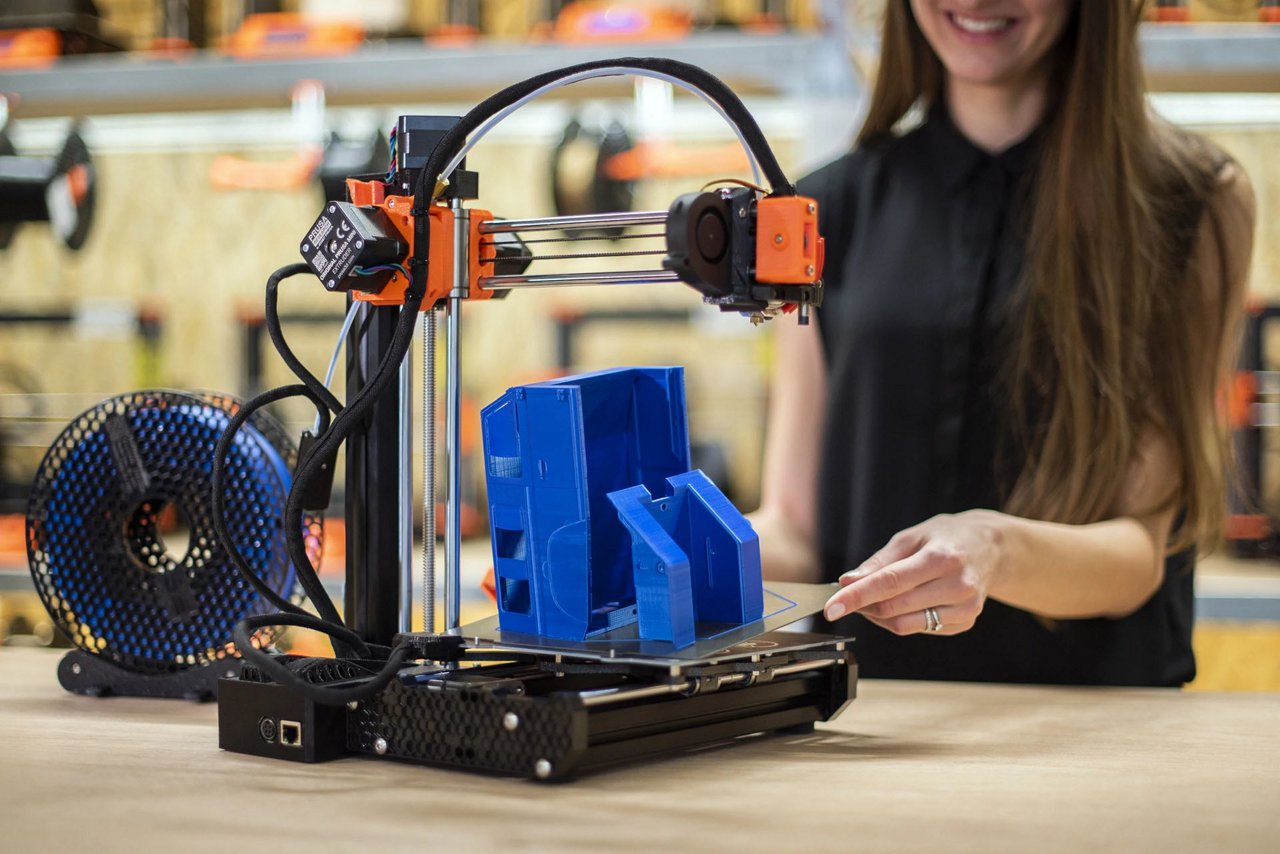 Stampante 3D in funzione, che produce un oggetto di plastica blu.