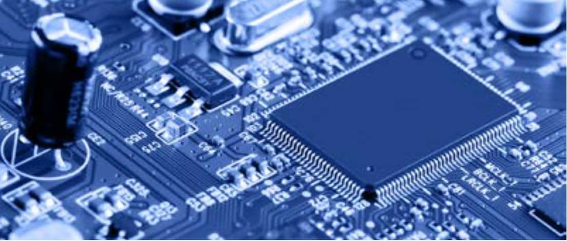 A detailed view of an electronic circuit board featuring a central microchip surrounded by various components. 