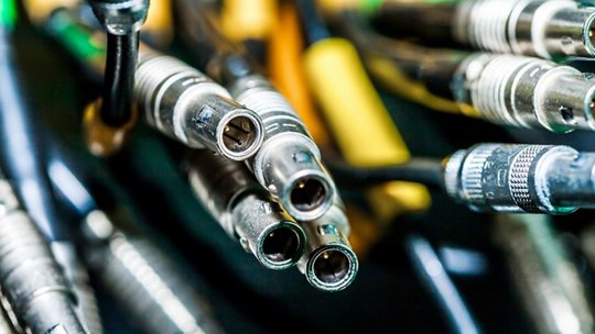 A detailed view of various audio cables and connectors, showcasing metallic finishes and intricate designs. 