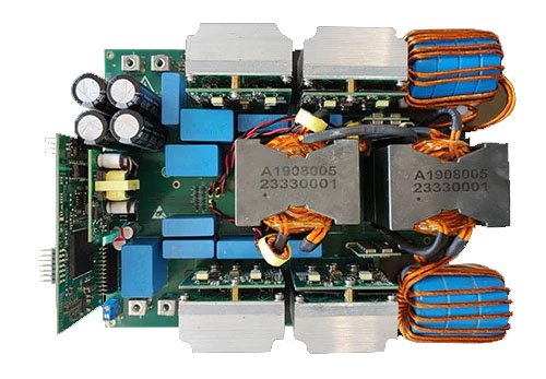 A detailed view of an electronic circuit board featuring multiple components, including capacitors, transformers, and wiring. The transformers are labeled with visible text 'A1908005' and '23330001'. 