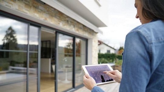 Donna che usa un tablet per controllare la casa intelligente
