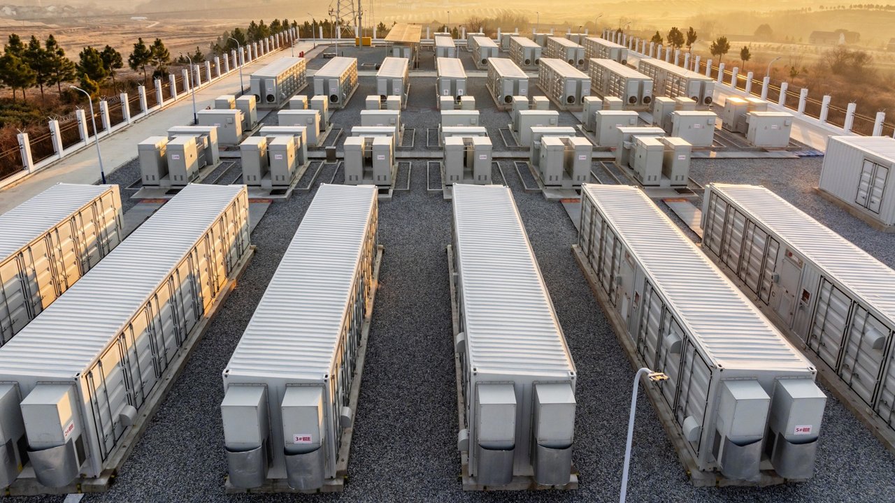 A sprawling battery storage facility featuring multiple white container units arranged in rows