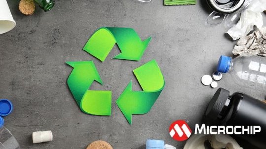 A green recycling symbol is prominently displayed on a gray surface, surrounded by various waste items including plastic bottles, paper cups, and metal caps.