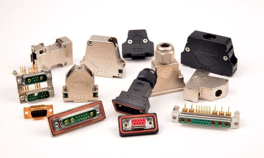A collection of various electronic connectors and adapters displayed on a white background. The assortment includes metallic and plastic components with visible pins and ports, such as a red 9-pin connector and green multi-pin configurations. The connectors vary in design and functionality, suitable for diverse electronic applications.