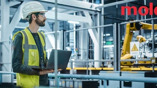 Industrial worker holds a laptop in a modern industrial factory