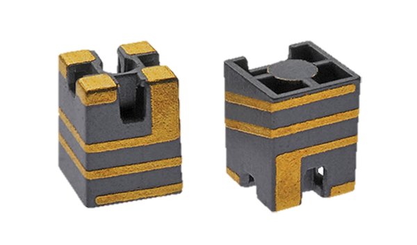 Two small electronic components with gold and black detailing are shown in close-up.