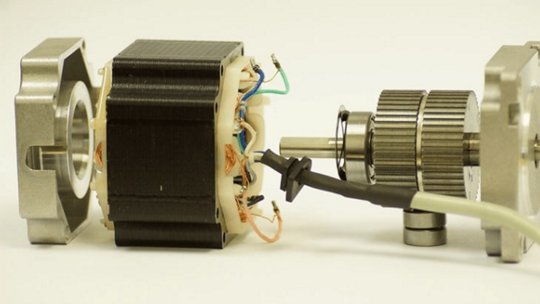 A close-up view of a disassembled stepper motor showcasing its internal components, including wiring and gears