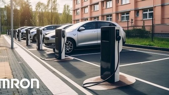 A row of electric vehicles parked at a modern charging station in an urban setting