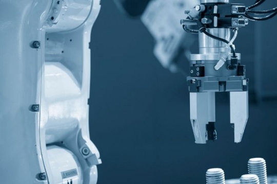 A close-up view of a robotic arm equipped with precision tools, actively working in an industrial setting.