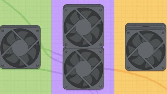 緑、紫、オレンジのカラフルなグリッドの背景に、3つの黒いコンピューター冷却ファンが置かれている。