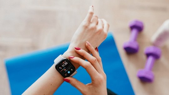 女性の手首に着用されたスマートウォッチがフィットネストラッキング機能を表示しているクローズアップ。