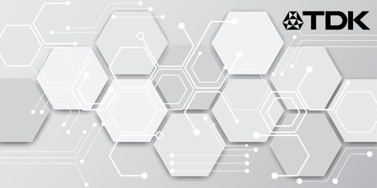 A futuristic design featuring white hexagonal patterns on a light gray background. The TDK logo is prominently displayed in the upper-right corner, adding a technological branding element. The visual evokes a clean, modern aesthetic with circuit-like connections.