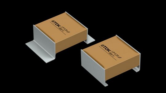 Two TDK capacitors are displayed against a black background.