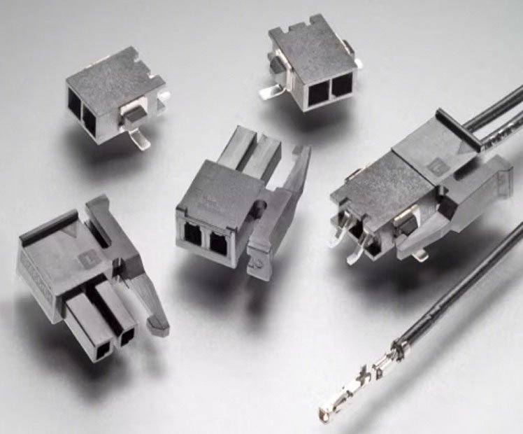 A collection of small electrical connectors displayed on a neutral grey surface. 