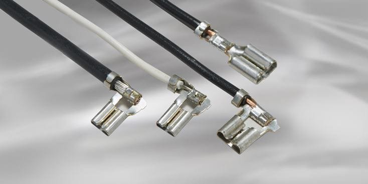 Una vista ravvicinata di quattro connettori per fili elettrici con terminali in metallo