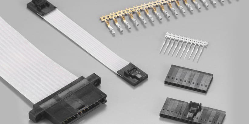 A flat ribbon cable with black plastic connectors is displayed alongside gold-plated pins and additional connector components
