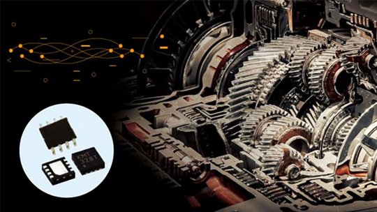 Close-up of automotive transmission gears and electronic components, including small circuit boards.