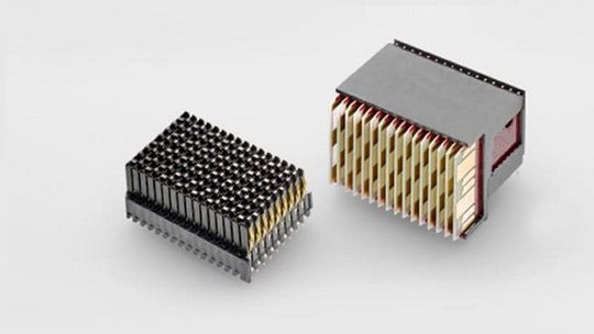 ニュートラルなグレーの背景に対して、2つのコンパクトな電子ヒートシンクが展示されています。デザインは、効率的な熱放散のために縦横に配置された金属製フィンが特徴的です。左側のユニットはより暗い仕上げになっており、右側のユニットはシルバーとゴールドのトーンを組み合わせたデザインを示しています。これらの部品は、電子機器の熱管理において不可欠な存在です。