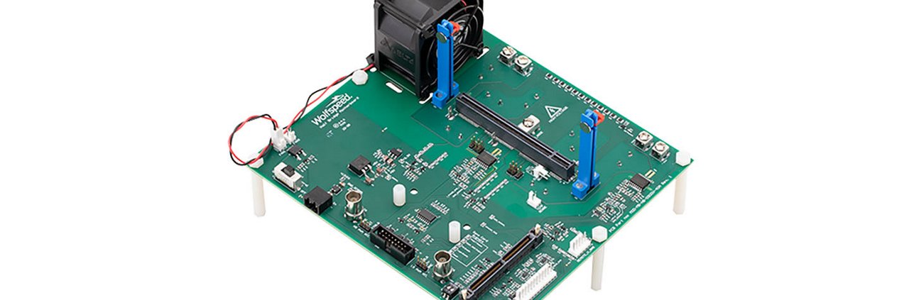 Eine grüne elektronische Leiterplatte mit verschiedenen Komponenten, darunter ein montierter Kühlventilator und Anschlüsse.