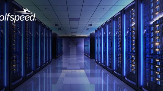 A modern data center featuring rows of illuminated server racks under blue ambient lighting. 