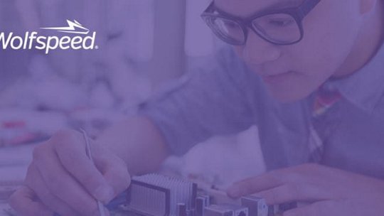 한 개인이 전문적인 환경에서 전자 부품을 조립하거나 검사하는 모습이 보인다.