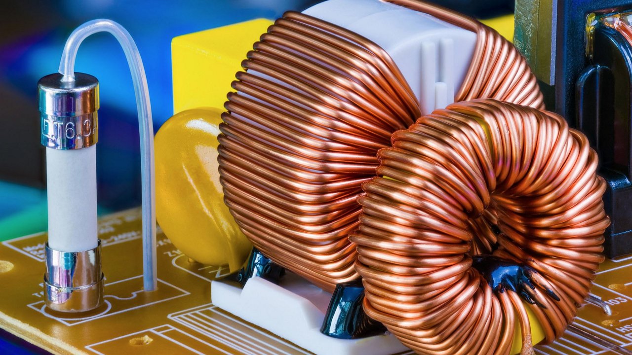 Eine detaillierte Ansicht einer Kupferspule-Komponente auf einer elektronischen Leiterplatte.